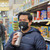 Man shopping whilst using sip valve on his mask